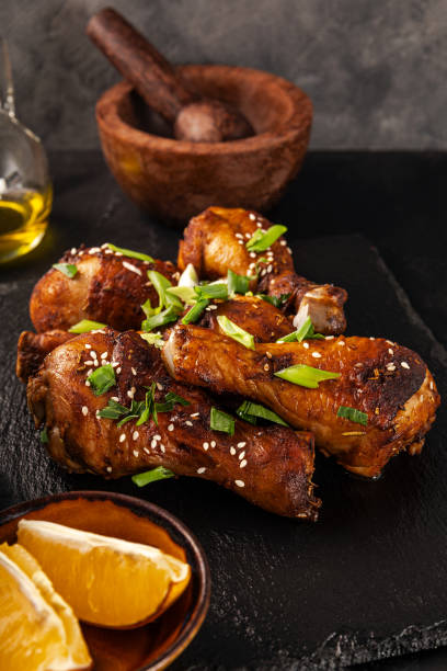 istock Chicken drumsticks with sesame seeds, Asian cooked chicken, black background vertical photo 1780542665