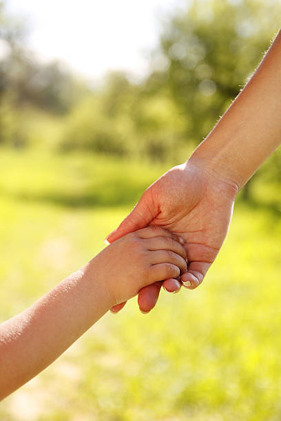 istock parent holds the hand of a small child 178054351