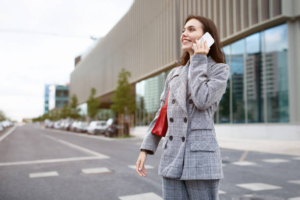 istock Employee lady talking on smartphone walking having conversation outdoor 1780553648