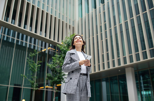 Business Application. Successful Young Businesswoman Using Smartphone Texting And Surfing Web Standing In Urban Area Outdoor Of Modern Office Building, Free Space For Text Advertisement