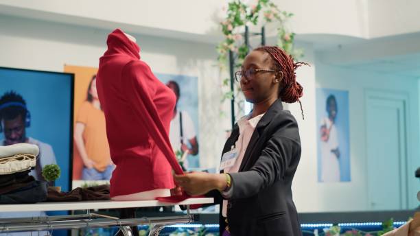istock Retail clerk puts clothes on mannequin 1780554978