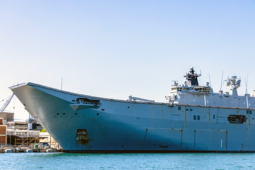 Superstructure of HMAS Adelaide moored at Garden Island in Sydney Harbour. This image was taken from Cowper Wharf at sunset in winter.