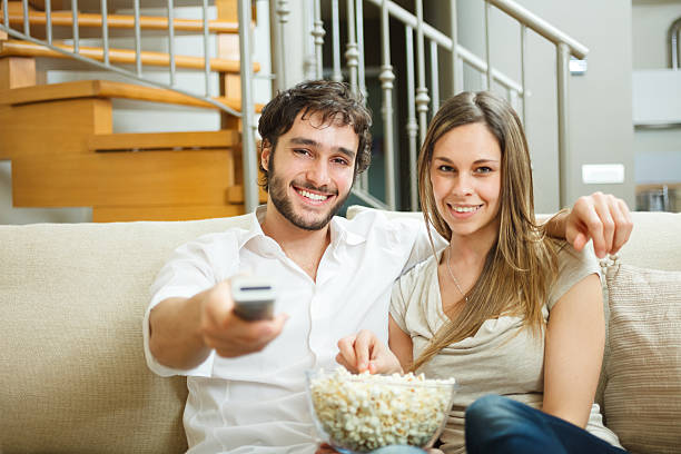 istock Couple eating popcorn while watching a movie 178057243