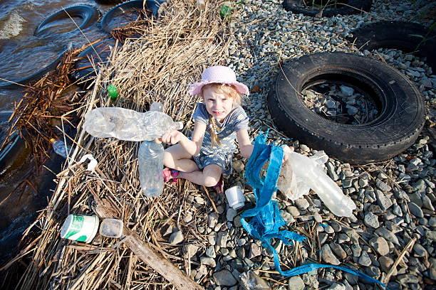 small girl collecting rubbish stock photo