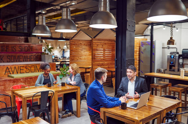 portrait businesspeople sitting indoors drinking coffee talking discussing