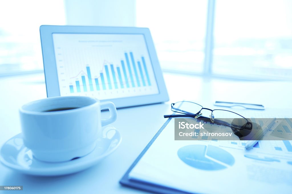 Office supplies Image of an office workplace with paper, touchpad and a cup of coffee Business Stock Photo