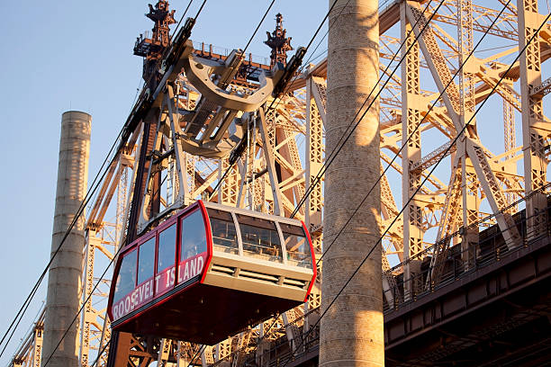 Cableway from Manhattan to Roosevelt Island. Red car of cableway near brridge from Manhattan to Roosevelt Island. roosevelt island stock pictures, royalty-free photos & images