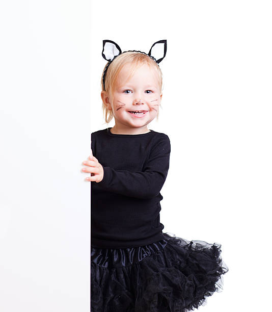 Girl in black cat costume with banner Cute little toddler girl with banner dressed for Halloween as black cat black cat costume stock pictures, royalty-free photos & images