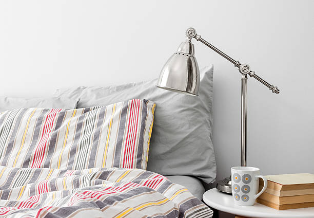 istock Lamp and books on a side table near bed 178061972