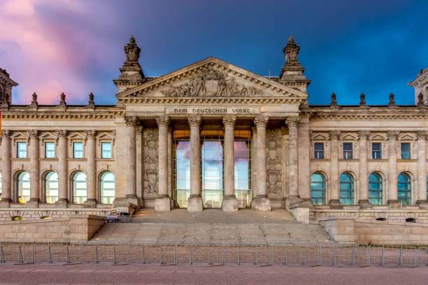 Reichstag building (Bundestag - parliament of Germany) in Berlin at sunset (inscription for German people)