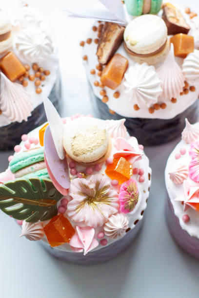 istock Orthodox easter bread richly decorated with sweets, macaroons, chocolate and edible flowers with salted caramel filling 1780632670
