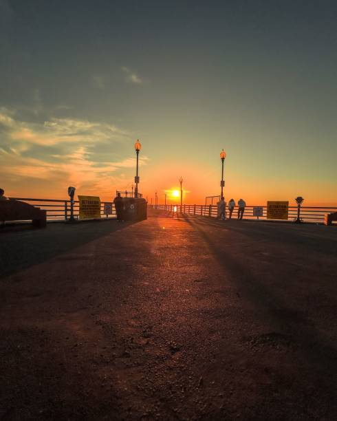istock a sunset at the beach with two benches and a street light 1780643797