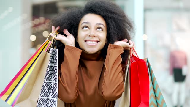 Portrait happy glad young woman shopper shopping in mall after sales and discount looking at camera