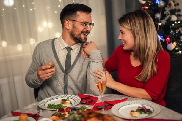 istock Couple drinking wine and laughing while sitting around a dining table during a dinner party 1780658380