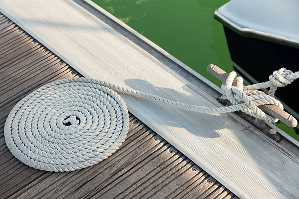 istock White rope coiled on a wooden dock 178066662