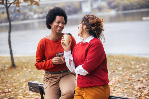 istock Two happy female friend talking enjoying autumn outdoors , drinks coffee. 1780667289