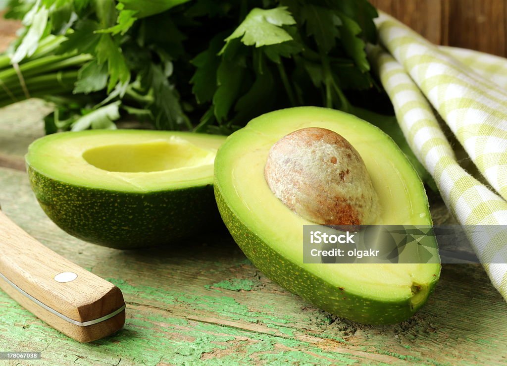 ripe avocado cut in half on a wooden table Agriculture Stock Photo