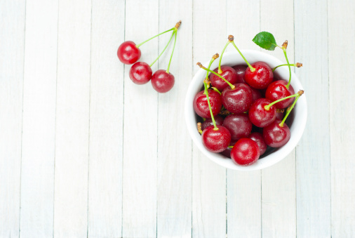 sour cherries on white wooden table, directly above