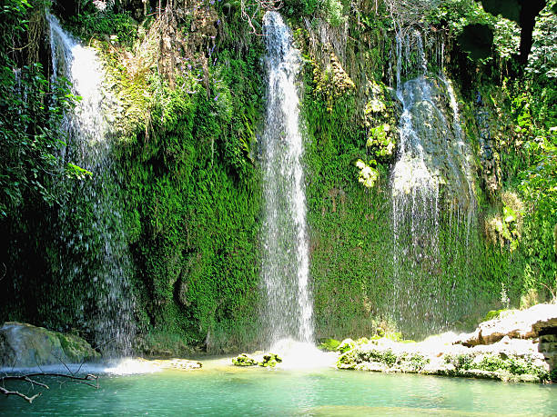 waterfall falling into blue lagoon in tropical deep forest waterfall cascade and lagoon pool in deep tropical forest kursunlu waterfall stock pictures, royalty-free photos & images