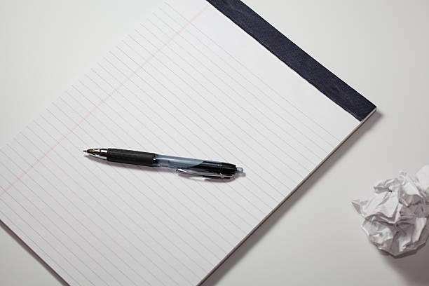 Notepad and pen with paperball slanted stock photo