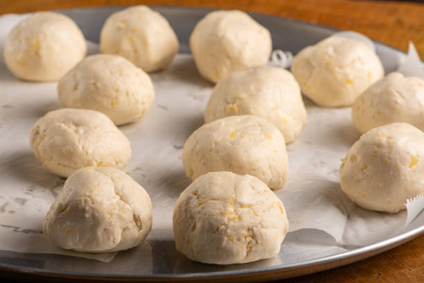 istock Cheese bread, pan with raw cheese breads ready to go in the oven, on rustic wood, selective focus. 1780721313