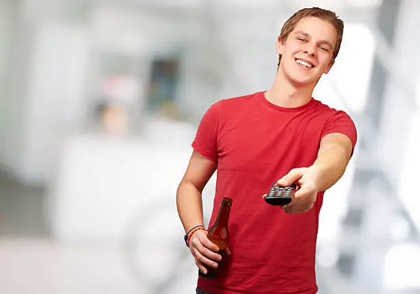 portrait of a young man with remote control, background