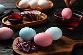 Naturally painted Easter eggs on black wooden table. Red cabbage used for coloring