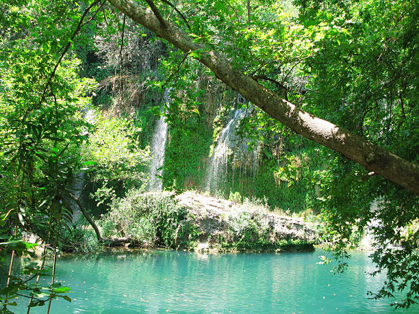 waterfall out of grotto cascade kursunlu turkey waterfall falling cascade and blue lagoon pool in deep forest kursunlu waterfall stock pictures, royalty-free photos & images