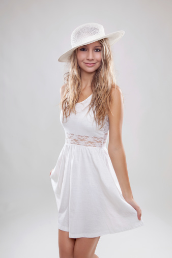 Young beautiful woman wearing a white dress and hat