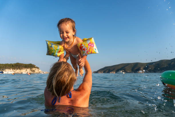 istock mom plays with baby in water 1780749000