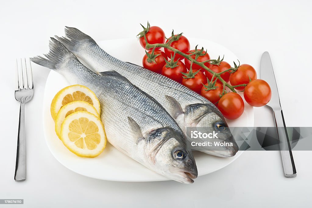2 つの魚のシーバス、トマト、レモン - かんきつ類のロイヤリティフリーストックフォト