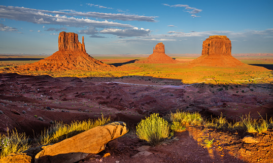 Monument Valley, on the Arizona - Utah border, gives us some of the most iconic and enduring images of the American Southwest.  The harsh empty desert is punctuated by many colorful sandstone rock formations.  It can be a photographer's dream to capture the ever-changing play of light on the buttes and mesas.  Even to the first-time visitor, Monument Valley will probably seem very familiar.  This rugged landscape has achieved fame in the movies, advertising and brochures.  It has been filmed and photographed countless times over the years.  If a movie producer was looking for a landscape that epitomizes the Old West, a better location could not be found.  This picture of the rock formations in the evening light was photographed from the Lee Cly Trail near the Monument Valley Visitor Center north of Kayenta, Arizona, USA.