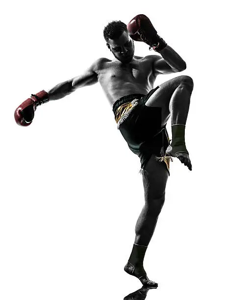 one caucasian man exercising thai boxing in silhouette studio on white background
