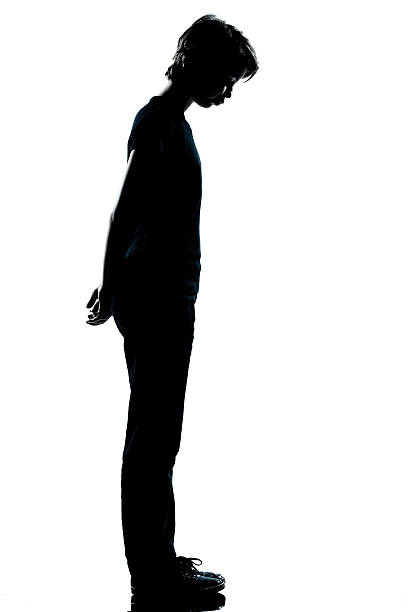 one young teenager boy or girl silhouette one caucasian young teenager silhouette boy or girl full length in studio cut out on white background sad child standing stock pictures, royalty-free photos & images