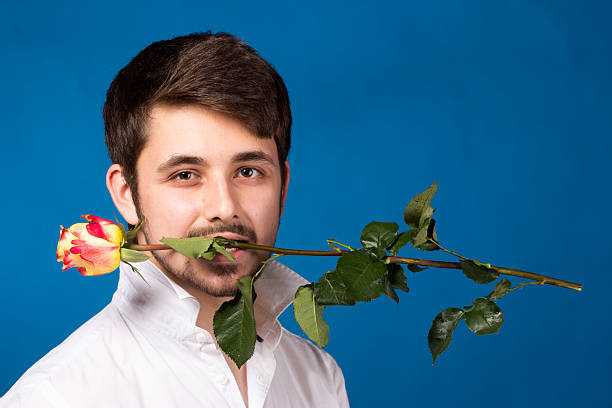 istock Young man holding a red rose in his mouth 178077693