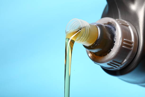 istock Can with car engine oil pouring blue background 178078026