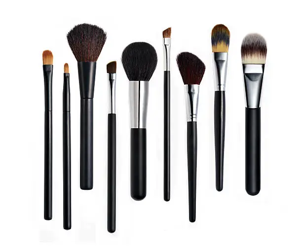 Photo of Set of various types of makeup brushes lined up in a row
