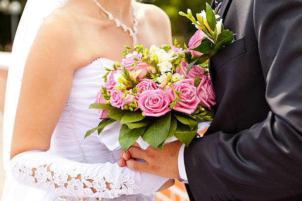 Bukiet ślubny w ręce nowożeńców – zdjęcie