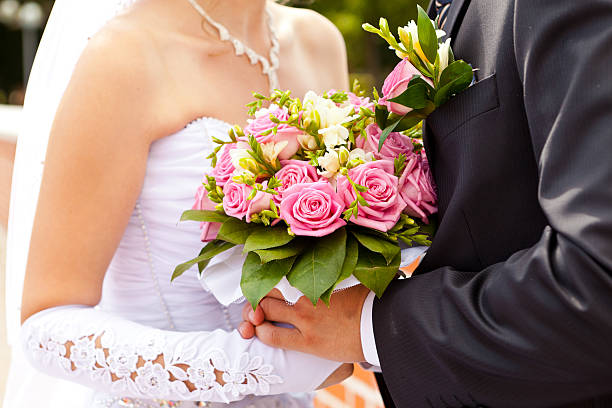 Buquê de casamento nas mãos dos recém-casados - foto de acervo