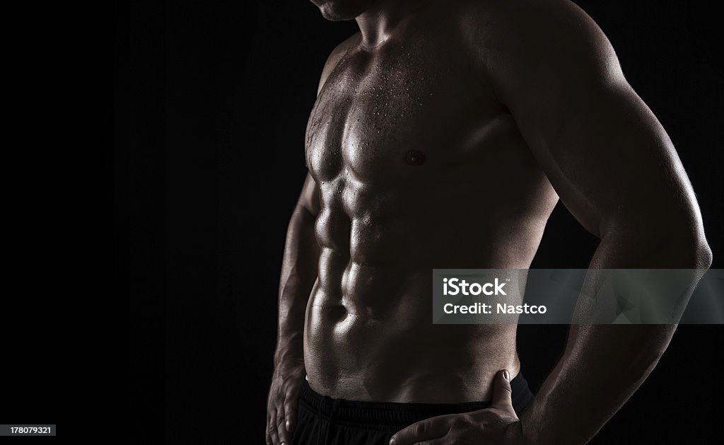 Athlete close up Close up of perfect male body isolated on black background with copy space Abdominal Muscle Stock Photo