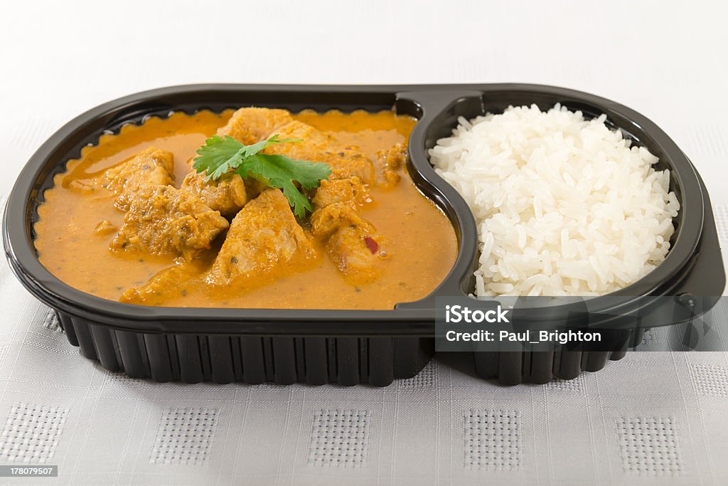 Takeaway Curry Takeaway Curry - Chicken curry with coconut milk and plain rice in a plastic container on a white background. TV Dinner Stock Photo
