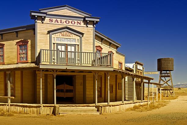 Old West Saloon A saloon, telegraph office and wooden water tower along the dirt road of an old American western town ghost town stock pictures, royalty-free photos & images