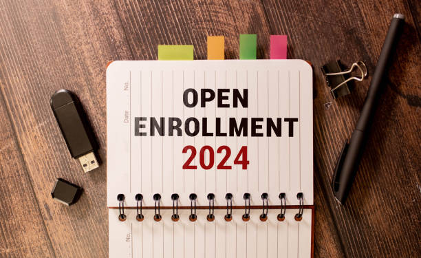 open enrollment 2024. text on a sticker next to money and banknotes. stock photo