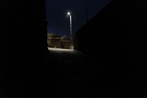 dark night with public lamp in a mystical atmosphere in the typical old streets of Malpica do Tejo, district of Castelo Branco, in the Portuguese region of Beira Baixa