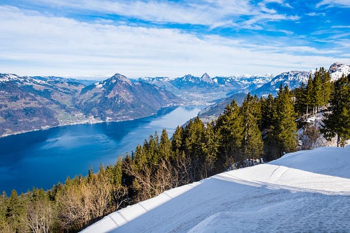 Panorama of Klewenalp mountains and Lake Lucerne or Vierwaldstattersee from mountain peak covered with snow. Popular ski resort in Swiss Alps and winter sport attraction in Switzerland in winter.