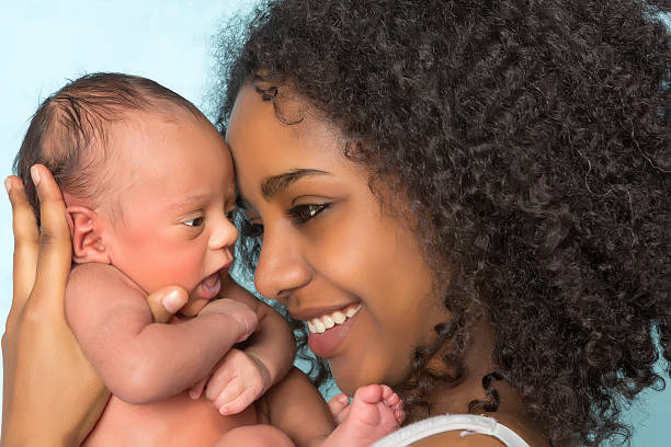 Smiling african mother and baby Smiling African mother holding her 11 days old newborn baby biracial newborn stock pictures, royalty-free photos & images
