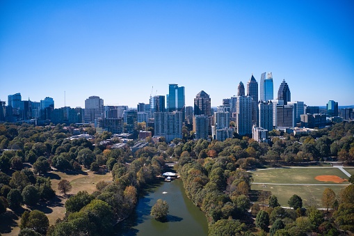 Panoramic aerial view of Atlanta skyline shot from Piedmont park with view of downtown skyline, lake Clara Meer and swimming pool in the park