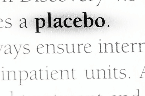 Placebo, part of experimental design is a control variable, printed in black on white page with focus on key word close-up.