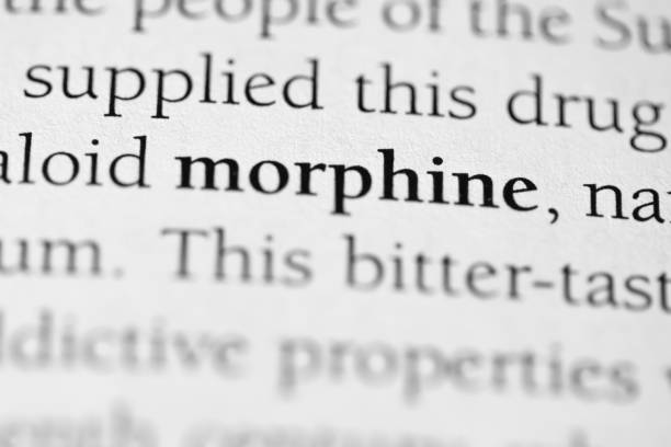 Morphine, addictive medical drug used for pain management and often abused, printed in black on white page of book close-up Morphine, addictive medical drug used for pain management and often abused, printed in black on white page of book close-up morphine drug stock pictures, royalty-free photos & images