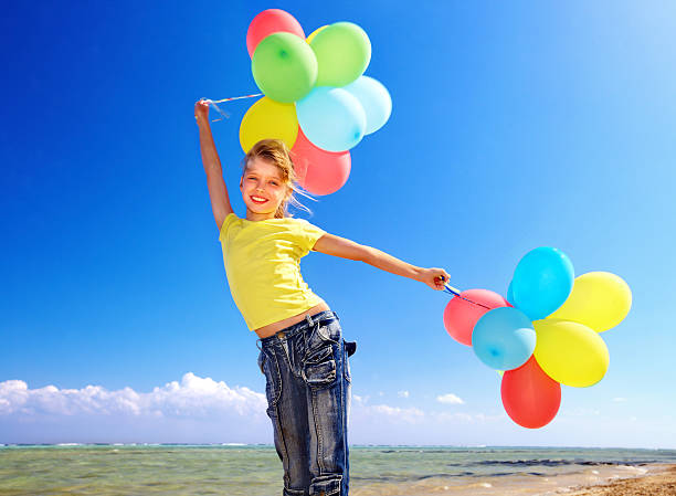 istock Kid playing with balloons at the beach 178084786
